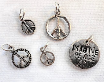 May include: Five silver charm pendants featuring peace signs and the phrase "Imagine Peace".