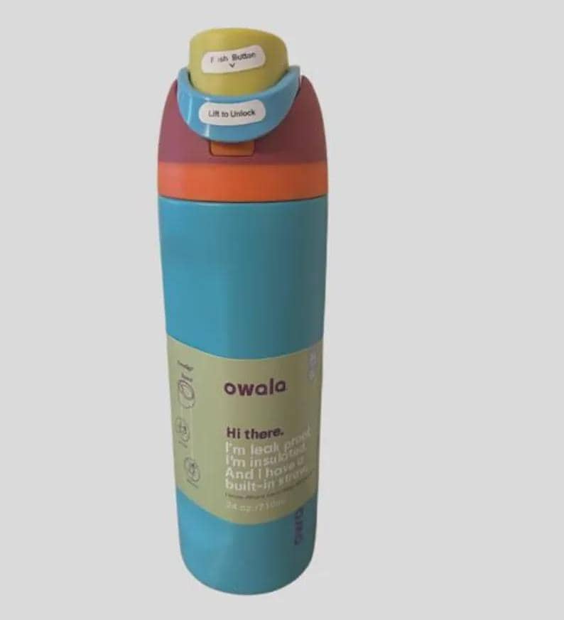 Op de afbeelding: Een meerkleurige Owala-waterfles met een blauwgroene behuizing, een oranje band en een kastanjebruin deksel met een lichtblauw vergrendelingsmechanisme en een gele drukknop. Het etiket bevat de tekst Owala, Hi there. I'm leak proof. I'm insulated. And I have a built-in straw. 24 oz/710ml.