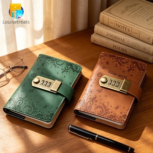 May include: Two rectangular journals with combination locks, one green and one brown, featuring embossed floral patterns and text. The green journal reads "Bloom slowly" and the brown journal reads "Keep going." A black pen and glasses are nearby.