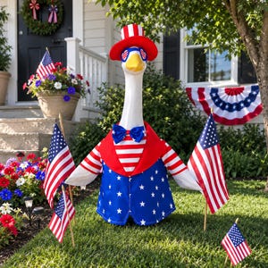 May include: A white goose statue wearing a red, white, and blue top hat, heart-shaped sunglasses, and a matching patriotic vest with a bow tie. The goose is surrounded by several small American flags on sticks, featuring red and white stripes and stars.