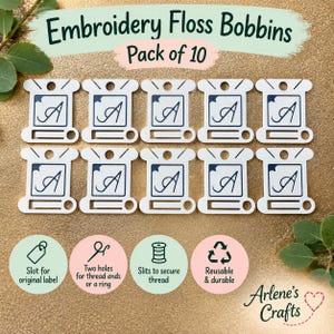 Puede incluir: Un paquete de 10 bobinas blancas para hilo de bordar con un gráfico de la letra A en azul oscuro. Cada bobina incluye un orificio superior, muescas laterales y una ranura inferior. El texto dice Embroidery Floss Bobbins Pack of 10, Arlene's Crafts, junto a iconos que describen ranuras para etiquetas, dos orificios, ranuras para hilo y material reutilizable.