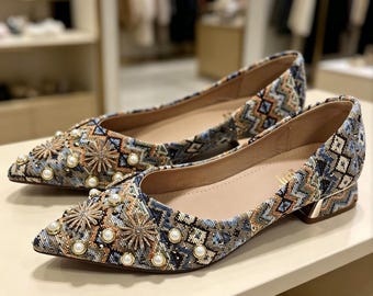Sapatos femininos de salto baixo com tapeçaria feita à mão e detalhes em pérola e strass.