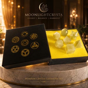 Op de afbeelding: Een zwarte doos met gouden geometrische symbolen en de tekst MOONLIGHTCRYSTA ENERGY | BALANCE | HARMONY met zeven lichtgroene kristalvormen op een felgele schuimrubberen inzetstuk, gelabeld PREMIUM CRYSTAL GEOMETRY SET.