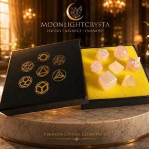 Op de afbeelding: Een zwarte doos met het label MOONLIGHTCRYSTA ENERGY | BALANCE | HARMONY met zeven lichtroze rozenkwartskristallen in diverse geometrische vormen, waaronder een bol, kubus en piramide, rustend op een felgele schuimrubberen inleg.