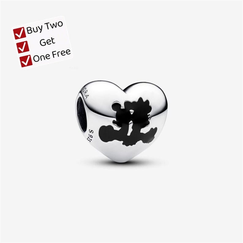 May include: A heart-shaped silver charm bead featuring a black silhouette of two cartoon characters kissing. The metal surface is engraved with the text PANDORA and S 925. A white square graphic in the corner displays the text Buy Two Get One Free.