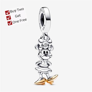 May include: A silver charm featuring a character with a bow, a small embedded stone, and gold-colored shoes. The charm has a bail stamped with the word PANDORA and S925. A white square graphic in the corner displays the text Buy Two Get One Free.
