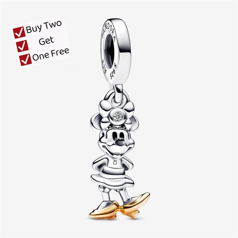 May include: A silver charm featuring a character with a bow, a small embedded stone, and gold-colored shoes. The charm has a bail stamped with the word PANDORA and S925. A white square graphic in the corner displays the text Buy Two Get One Free.