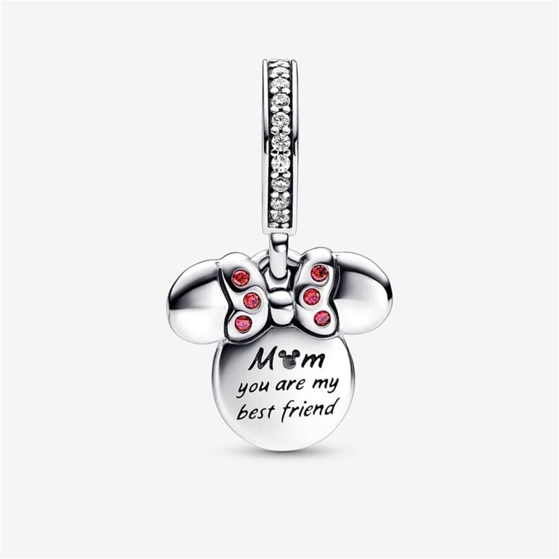 May include: A silver-toned metal charm shaped like a bow-wearing character head. The bow is accented with small red stones. The bail is set with clear crystals. The front features the text "Mom you are my best friend" with a small icon of a head.