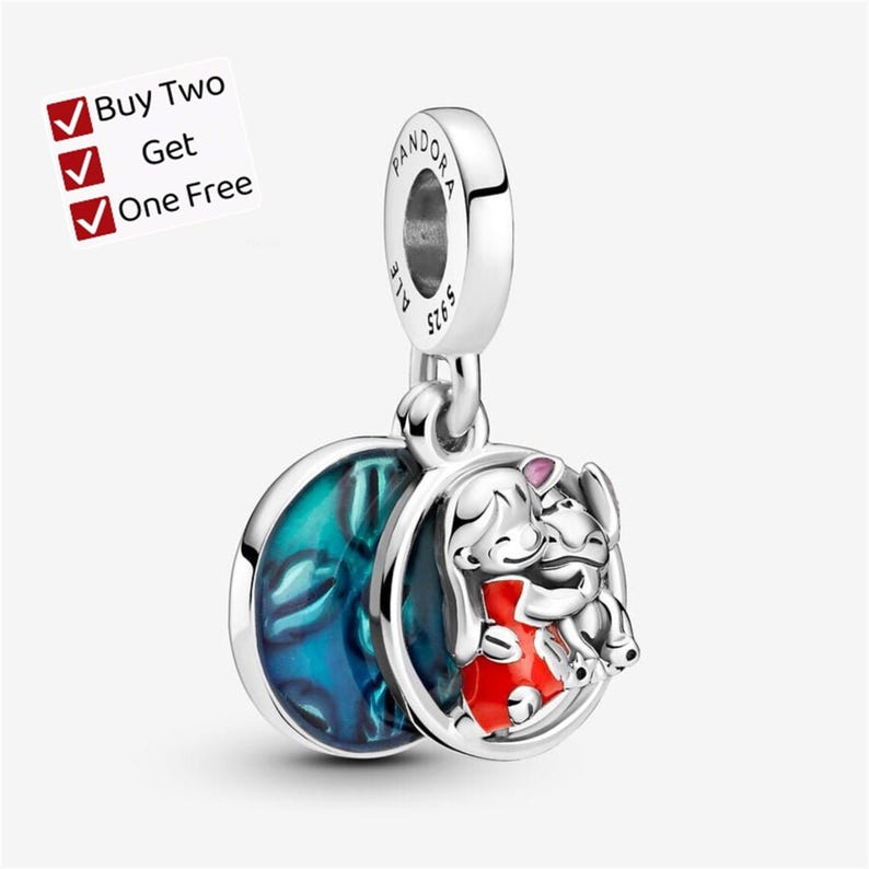 May include: A silver charm featuring a circular pendant with a blue enamel background and a raised figure of a character in a red dress hugging a small creature. The bail is engraved with Pandora and S925. Text reads: Buy Two Get One Free.