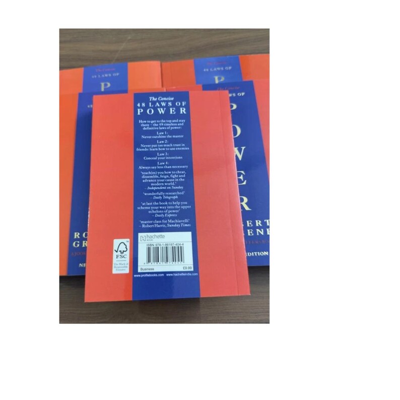 May include: A stack of paperback books titled The Concise 48 Laws of Power by Robert Greene. The back covers are orange with a central blue vertical stripe containing white text, a barcode, and an FSC logo. The books are arranged in a cluster.