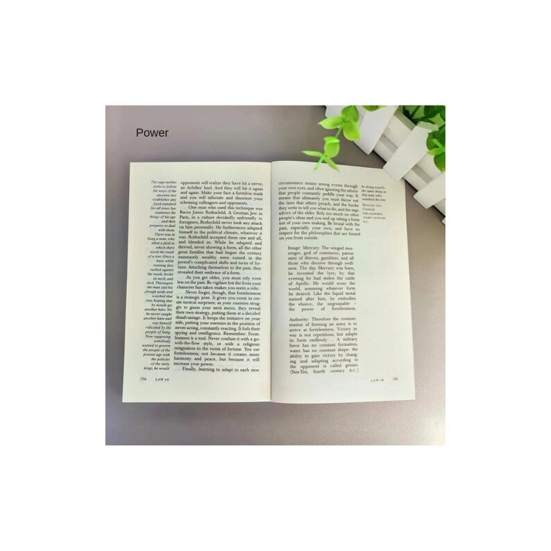 May include: An open book with white pages and black printed text, featuring the word Power at the top left. The text is arranged in two columns across the pages, with visible page numbers at the bottom corners. The book is resting on a flat surface.