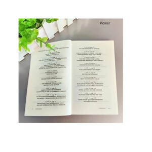 May include: An open book displaying a table of contents with the heading Power. The text lists laws from 11 to 30, including titles like Learn to Keep People Dependent on You, Play a Sucker to Catch a Sucker, and Make Your Accomplishments Seem Effortless.