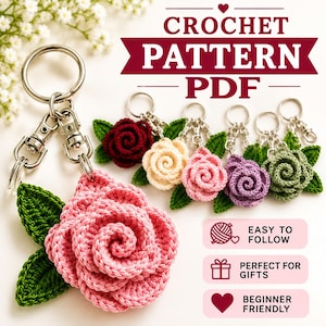 May include: A crochet pattern PDF featuring a pink rose keychain with green leaves attached to a silver metal ring. Additional rose keychains in dark red, cream, light pink, purple, and green are displayed. Text reads CROCHET PATTERN PDF.