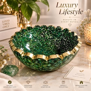 Può includere: Una ciotola decorativa con un interno verde intenso riempito di piccoli frammenti di pietra verde e un bordo smerlato in oro metallizzato. La ciotola presenta un'ampia apertura circolare e una finitura liscia e riflettente sul bordo dorato esterno.