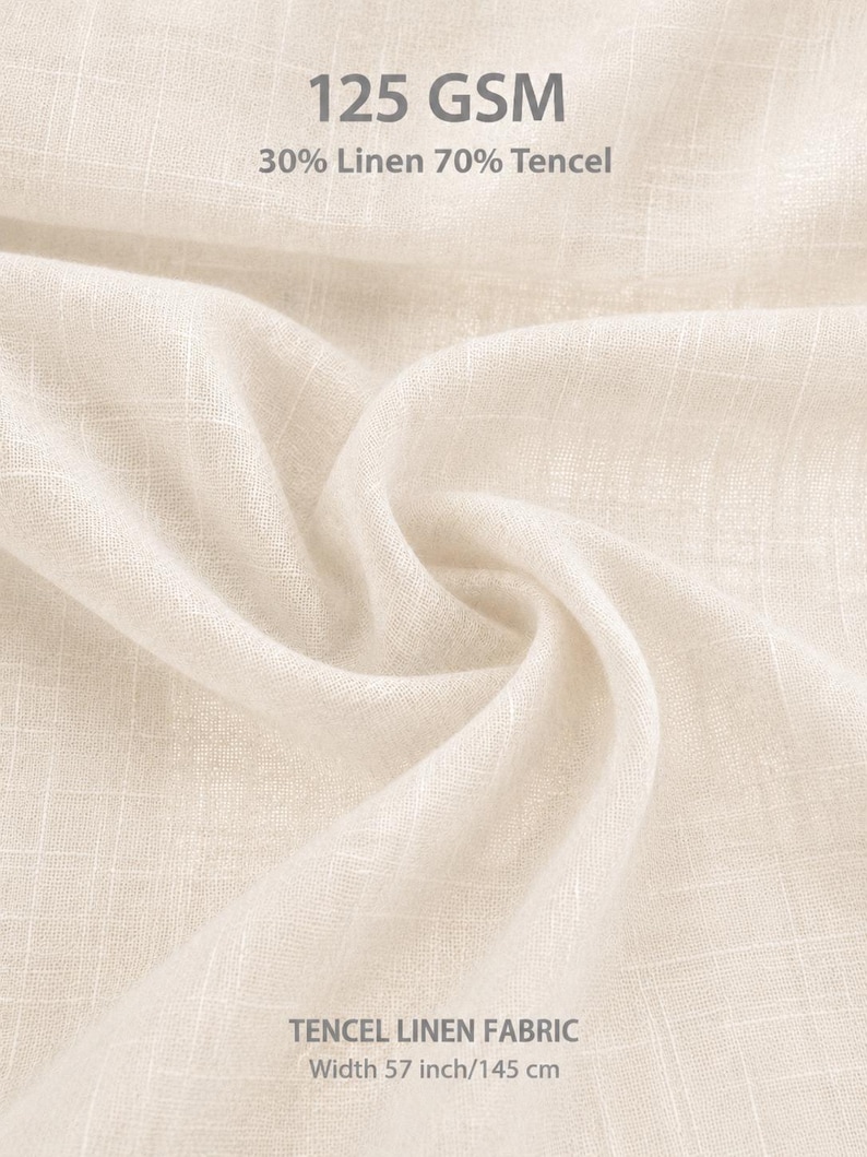May include: A light beige fabric with a visible weave texture. The text on the fabric reads 125 GSM, 30% Linen 70% Tencel, TENCEL LINEN FABRIC, and Width 57 inch/145 cm. The material is draped to show its soft, lightweight, and semi-sheer quality.