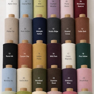 May include: A collection of thirty fabric bolts arranged in a grid, each labeled with a number and color name. The colors include white, blue, green, purple, pink, red, beige, gray, navy, charcoal, brown, black, orange, yellow, and cream.