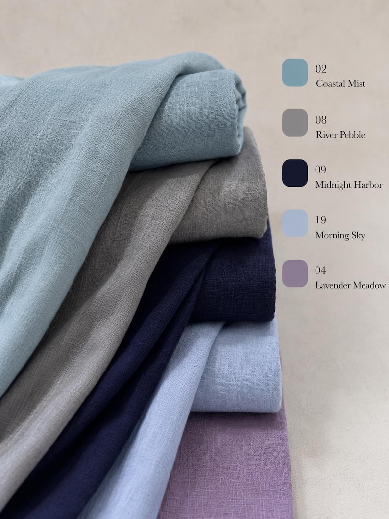 May include: A stack of folded fabric in five distinct colors with a corresponding color chart on the right. The colors are labeled 02 Coastal Mist, 08 River Pebble, 09 Midnight Harbor, 19 Morning Sky, and 04 Lavender Meadow in a list format.