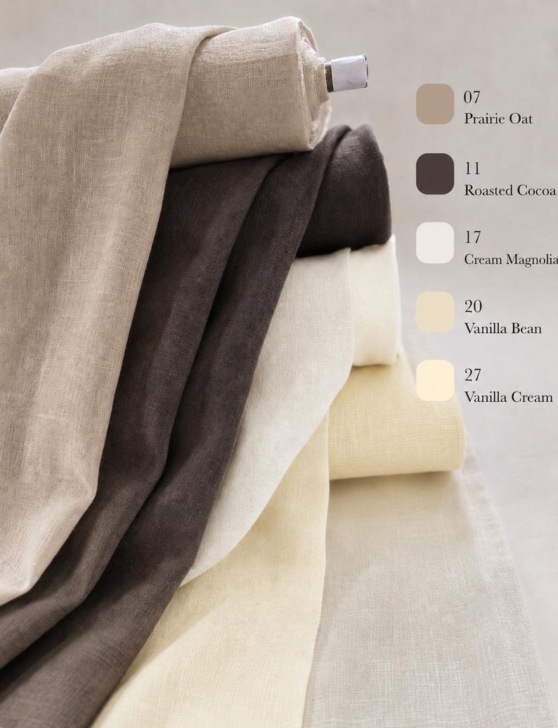 May include: A stack of fabric rolls in various neutral shades including Prairie Oat, Roasted Cocoa, Cream Magnolia, Vanilla Bean, and Vanilla Cream. Each roll is labeled with its corresponding color name and number, showcasing the texture of the fabric.