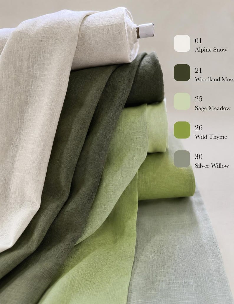 May include: A stack of five folded linen fabric bolts in shades of white, dark green, light green, olive green, and gray. The colors are labeled as 01 Alpine Snow, 21 Woodland Moss, 25 Sage Meadow, 26 Wild Thyme, and 30 Silver Willow on the right.