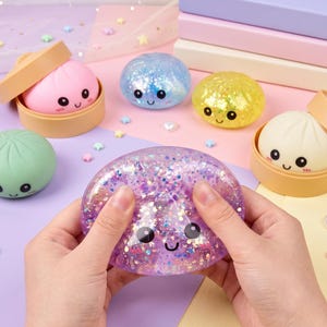 May include: A collection of squishy dumpling toys with smiling faces, including a pink one in a tan steamer, a green one, a blue glitter one, a yellow glitter one, a white one in a tan steamer, and a purple glitter one being squeezed.