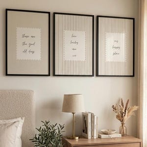 May include: Three framed wall art prints with black frames. The left print says "these are the good old days", the centre print says "how lucky are we", and the right print says "my happy place". Each print features a scalloped edge white centre.