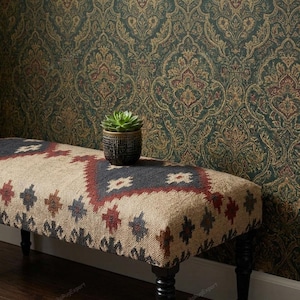 May include: A rectangular bench with a woven beige surface featuring a dark grey and red diamond pattern. The bench has four black turned wooden legs and supports a small green succulent plant in a dark textured pot on its top surface.