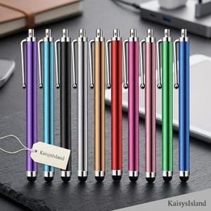 May include: A set of ten slim stylus pens in various colors including purple, light blue, black, silver, gold, red, magenta, pink, green, and blue. Each pen features a silver clip, a click-top mechanism, and a black rubber tip. A tag reads KaisysIsland.