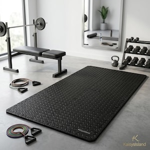 May include: A rectangular black exercise mat with a textured diamond plate pattern and the text KaisysIsland printed in the corner. The mat is positioned on a floor near a weight bench, a rack of dumbbells, a kettlebell, and two sets of resistance bands.