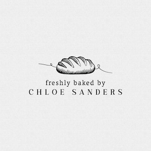 May include: A black and white line drawing of a loaf of bread with the text "freshly baked by CHLOE SANDERS". The bread illustration is detailed with curved lines, suggesting texture and shape. The text is in a simple, clean font.