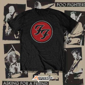 Puede incluir: Una camiseta de manga corta gris carbón que presenta el logotipo de Foo Fighters en un círculo rojo con un borde blanco en el pecho. La camiseta se muestra sobre un fondo de collage de fotografías de la banda en blanco y negro y el texto Foo Fighters.