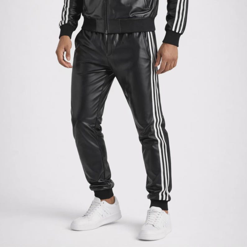 May include: Black faux leather track pants featuring three vertical white stripes running down the outer sides of each leg, paired with a matching black track jacket with white stripes on the sleeves and white sneakers.