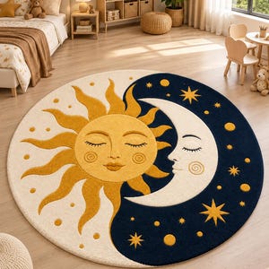 Può includere: Un tappeto rotondo con un design diviso che presenta un sole giallo su sfondo crema e una luna crescente bianca su sfondo blu navy scuro. Sia il sole che la luna hanno tratti del viso e la sezione blu navy è decorata con stelle gialle.
