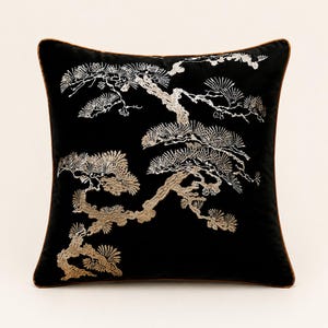 May include: A square black scatter cushion featuring intricate gold and silver thread embroidery of a sprawling pine tree. The design covers the front surface, and the cushion is finished with a thin, dark brown piping along all four edges.