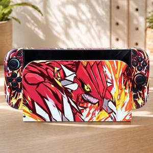 Puede incluir: Una base para consola de videojuegos y dos mandos extraíbles con un gráfico vibrante de una criatura roja de dientes afilados con púas blancas, rodeada de llamas estilizadas de color naranja y amarillo en la parte frontal.