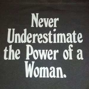 ¡Nunca subestimes el poder de una mujer! por King George ll Studios imagen 1