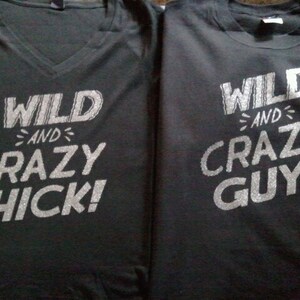 May include: Two black t-shirts with silver glitter text. The first shirt says "WILD AND CRAZY CHICK!" The second shirt says "WILD AND CRAZY GUY!"