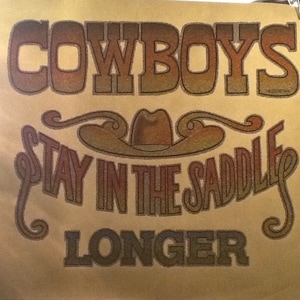 Puede incluir: Un póster vintage con un sombrero de vaquero y el texto "Cowboys Stay in the Saddle Longer". El texto está en una fuente colorida y en capas.