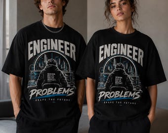 Puede incluir: Una camiseta negra de manga corta con un estampado gráfico de una persona frente a un ordenador, con el texto "ENGINEER PROBLEMS" en letras blancas grandes, "DESIGN, BUILD, SOLVE, REPEAT." y "SHAPE THE FUTURE" en la parte inferior.