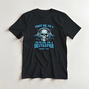 May include: A black short-sleeve t-shirt featuring a graphic of a skull wearing headphones with a microphone. The text reads: TRUST ME, I'M A DEVELOPER, with code brackets and the text DevSync Labs printed in light blue on the front of the shirt.