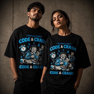 Op de afbeelding: Een zwart t-shirt met korte mouwen en een grafische print met de tekst DevSync Labs CODE & CRASH. Het ontwerp toont een persoon met een koptelefoon, zittend achter een computer met een mok, een klok en een omgevallen beker in blauw en wit.
