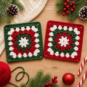 Puede incluir: Dos cuadrados de ganchillo tipo granny square con un motivo floral blanco central rodeado por capas alternas de hilo rojo y verde oscuro. Los cuadrados están dispuestos uno al lado del otro, mostrando un patrón geométrico clásico.