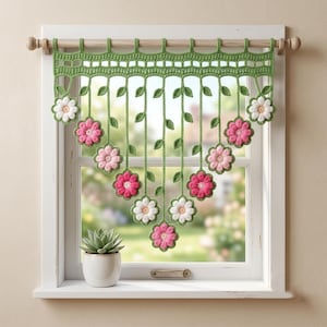 May include: A crochet window valance featuring a green lattice top border with hanging vertical strands. Each strand is adorned with small green leaves and finished with a single crocheted flower in shades of white, light pink, and dark pink.