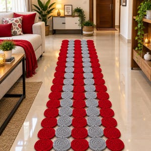 Puede incluir: Una alfombra de pasillo rectangular larga compuesta por motivos circulares de ganchillo interconectados. El diseño presenta dos columnas exteriores de círculos rojos sólidos y una columna central de círculos gris claro, creando un patrón geométrico repetitivo.