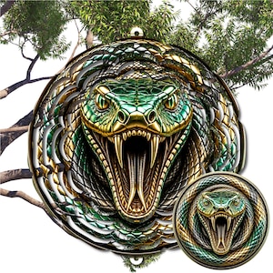 May include: A circular metal wind spinner featuring a detailed, high-contrast graphic of a green and gold snake with its mouth open, revealing sharp fangs. The design includes a smaller, identical circular version positioned in the lower right corner.