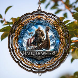 May include: A circular hanging ornament featuring a central illustration of a Viking warrior standing on a longship with a dragon-headed prow. The image includes snowy mountains and the text "HAIL, TRAVELER!" surrounded by an intricate, layered bronze-coloured frame.