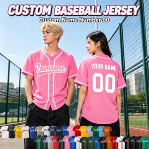May include: A bright pink short-sleeved baseball jersey featuring a button-down front with white piping. The front displays the text Teamname in white script, while the back shows the text YOUR NAME and the number 00 in white block lettering.