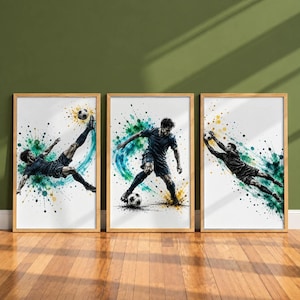 Op de afbeelding: Een set van drie ingelijste wandposters met aquarel-stijl illustraties van voetballers in actie. De kunstwerken tonen een speler die een omhaal maakt, een speler die dribbelt en een keeper die een duikende redding uitvoert.