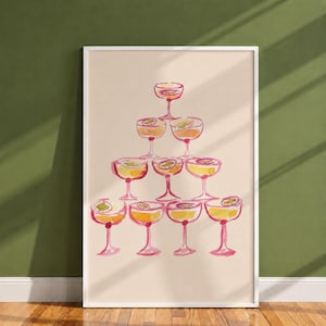 Può includere: Una stampa artistica incorniciata con un'illustrazione ad acquerello di una piramide di dieci bicchieri da cocktail. Ogni bicchiere è riempito con un liquido giallo e guarnito con una fetta di frutto della passione, nei toni del rosa, giallo e arancione.