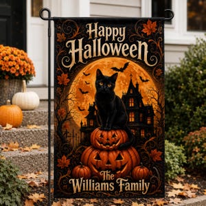 May include: A rectangular garden flag featuring a black cat sitting on a stack of two carved jack-o'-lanterns. The background displays a large orange moon, a dark haunted house, bats, and autumn leaves. The text reads Happy Halloween and The Williams Family.