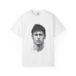 Può includere: Una t-shirt bianca a maniche corte con un dettagliato ritratto in bianco e nero, in stile matita, di una persona con capelli corti e una fascia. Sotto il ritratto si trova una firma in stile manoscritto realizzata con inchiostro nero.